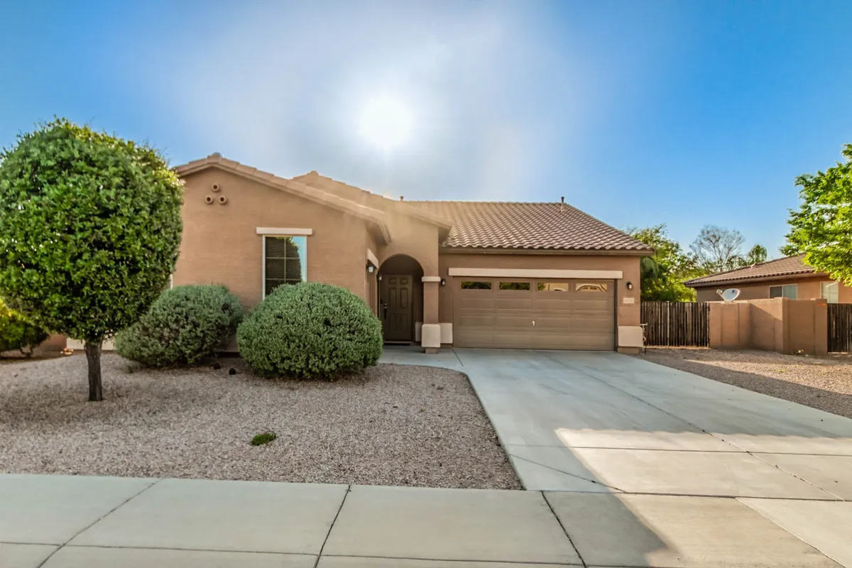 The welcoming front entrance of a home is framed by beautifully landscaped shrubs and a well-maintained garage door. There's a clear atmosphere of community and outdoor activity, with the inviting exterior suggesting a safe and family-oriented environment perfect for gatherings or play just outside the front door.