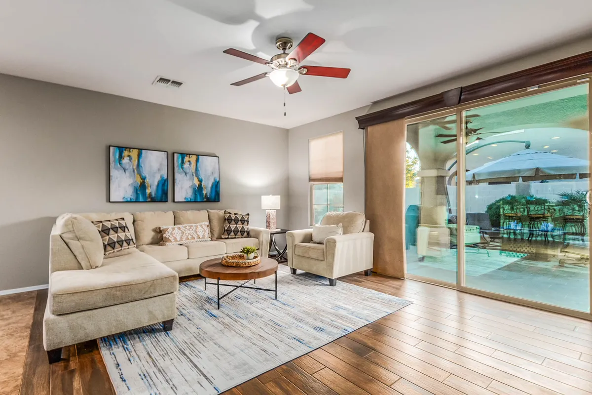 A bright and spacious living room featuring a comfortable sofa, stylish coffee table, tasteful artwork, and large windows letting in abundant natural light. The space feels open and inviting, ideal for both quiet moments and social gatherings.
